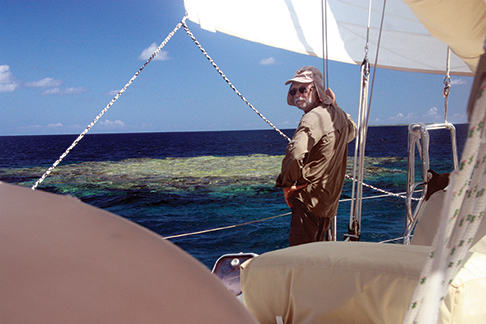 Dressed for the strong sun and sailing close by the reefs in deep water