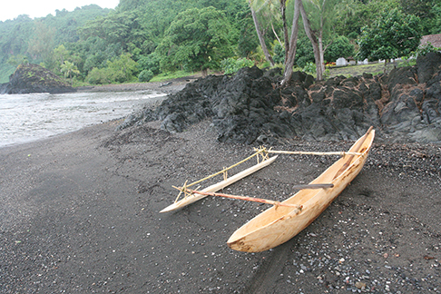 Newly built dugout canoe on black sand beach at Sasara Twin Waterfall Bay