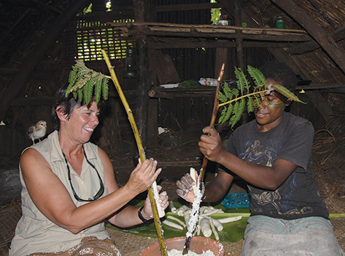 Grating manioc for laplap on black palm branches